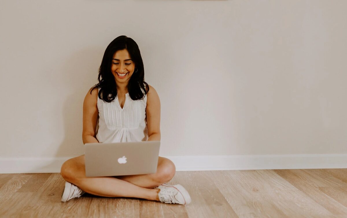 Arundhati smiling at a laptop, leading a live online class from the studio.
