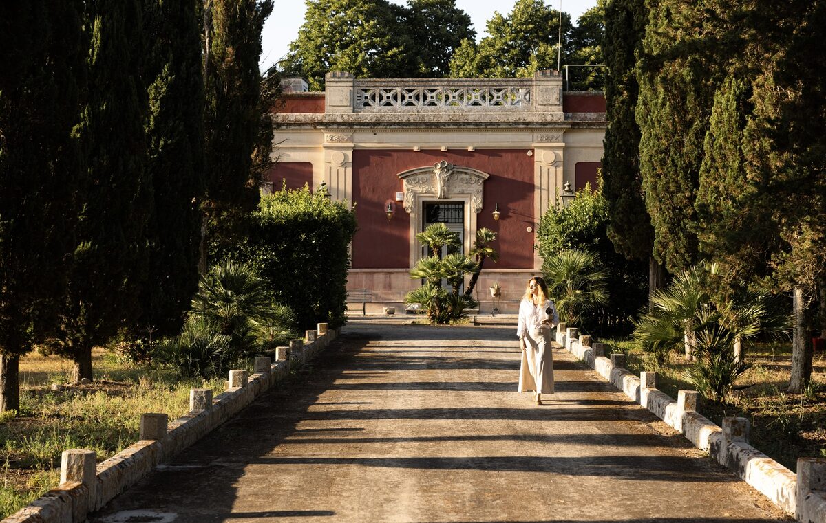 A cypress-lined stone path leading to a villa — the setting for the annual retreat.